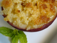 A baked nectarine half topped with almond crumble