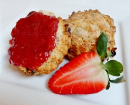 Photo of fruity breakfast scones with some no-added-sugar strawberry spread and half a strawberry