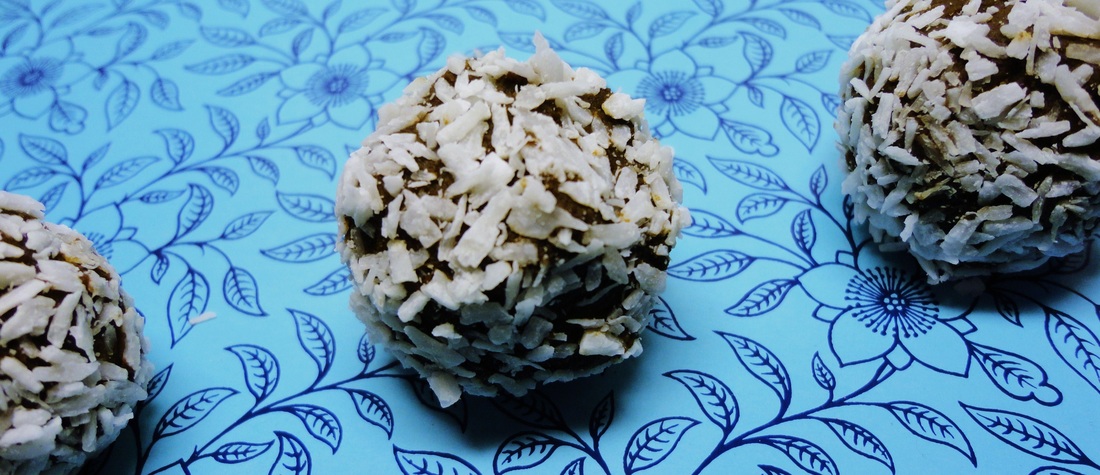 A photograph of three coconut and chocolate truffles